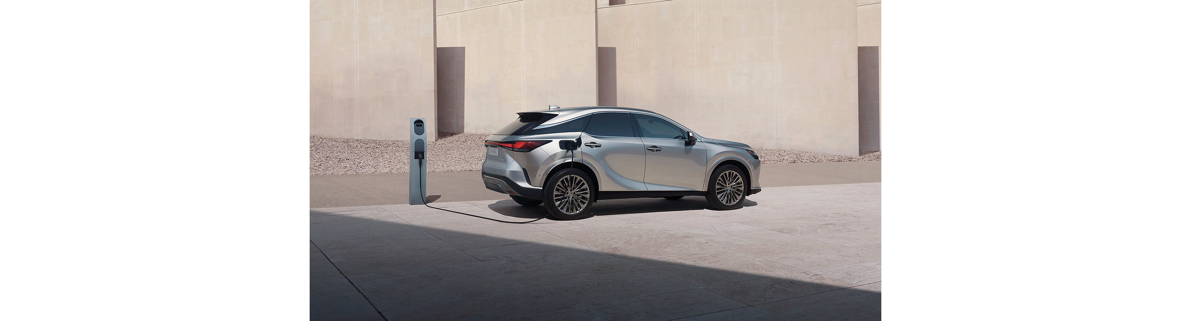 Lexus RX 450h+ plugged into a charging tower