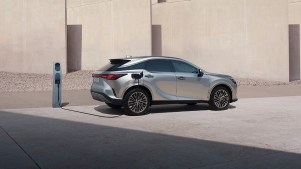 Lexus RX 450h+ plugged into a charging tower