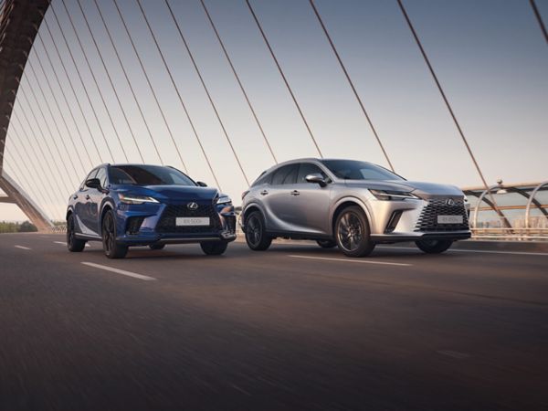 A Lexus RX 500h and Lexus RX 450h+ driving across a bridge