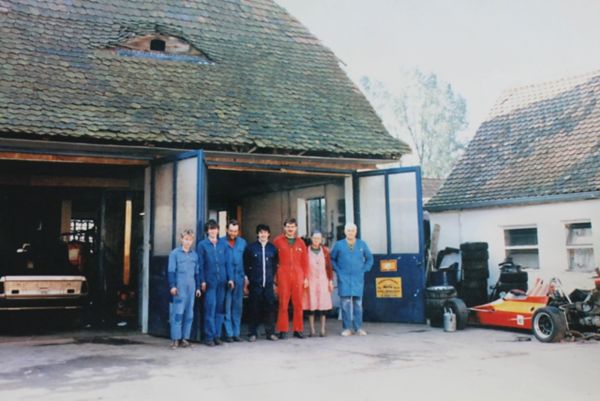 Mehrere Personen stehen vor einer Garage nebeneinander