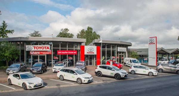 Außenansicht des Autohaus S+K mit Toyota-Fahrzeugen im Vordergrund