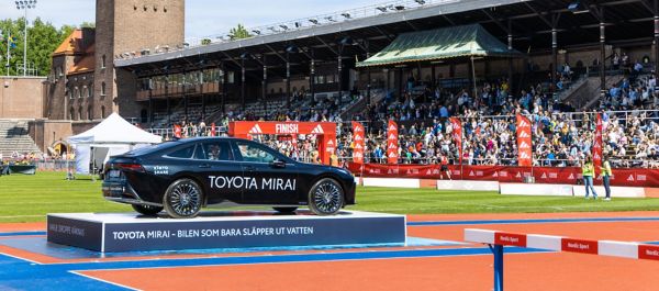 En svart Toyota Mirai står uppställd på ett podium på ett soligt Stockholms Stadion vid Stockholms Maratons målgång..