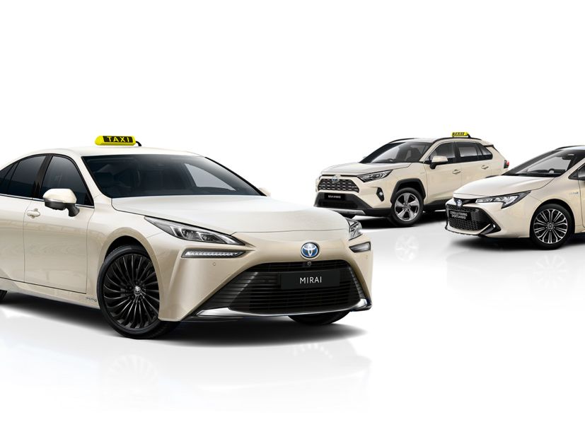 Drei beige Taxi Autos vor weißem Hintergrund mit dem Toyota Mirai im Vordergrund.