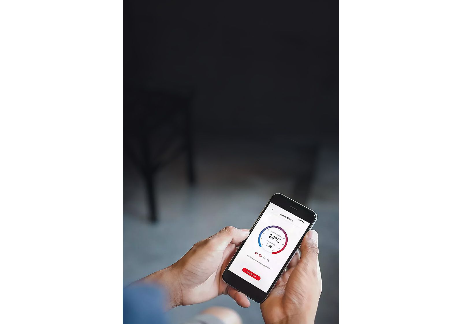 Smartphone in der Hand einer Person, darauf eine App zum Bedienen der Klimatisierung zu sehen.
