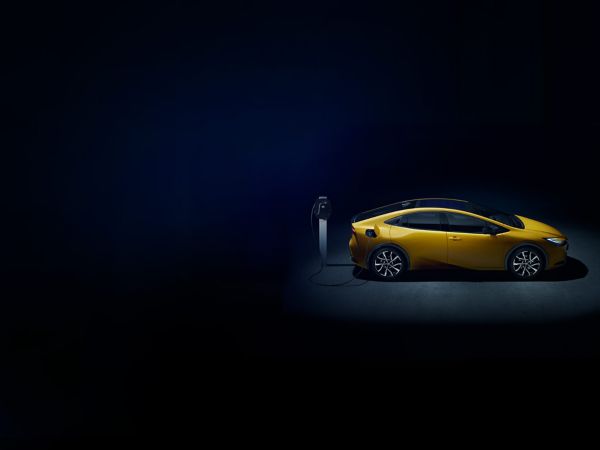 Plug-in Hybrid ist verbunden mit einer Ladesäule vor blauem Hintergrund