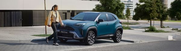 Žena s mužem vyndávají nákupy ze střešního boxu nového vozu Corolla Cross