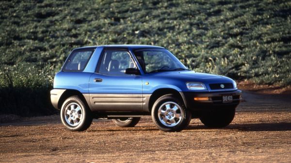 Toyota RAV4 dwudrzwiowa z lat 90. zaparkowana na drodze gruntowej wśród zieleni
