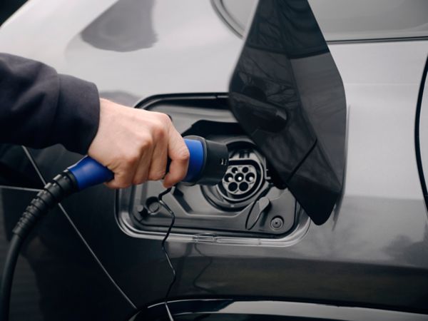 Man plugging in electric vehicle