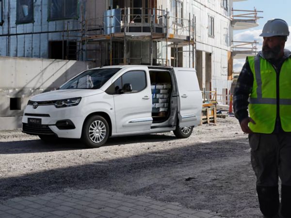 Mann steht auf der Ladefläche eines Pick-Up Trucks