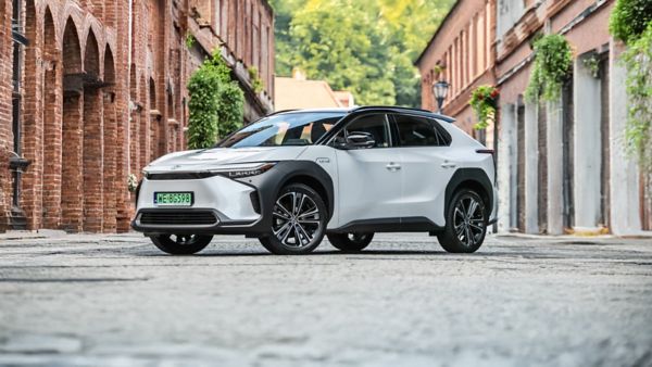 Toyota bZ4X zaparkowana między budynkami z czerwonej cegły