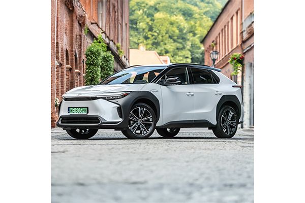 Toyota bZ4X zaparkowana między budynkami z czerwonej cegły