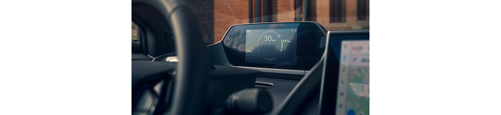 Blick von hinten auf das Cockpit des Toyota bZ4X, man blickt auf das Multimeter vorm Lenkrad, das Geschwindigkeit und weitere Informationen anzeigt.