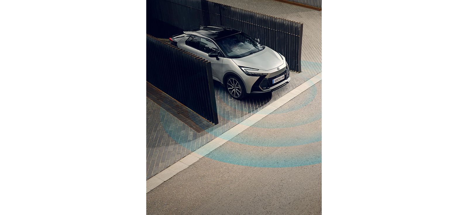 Unter einem geparkten Toyota C-HR pulsieren animierte blaue Wellen