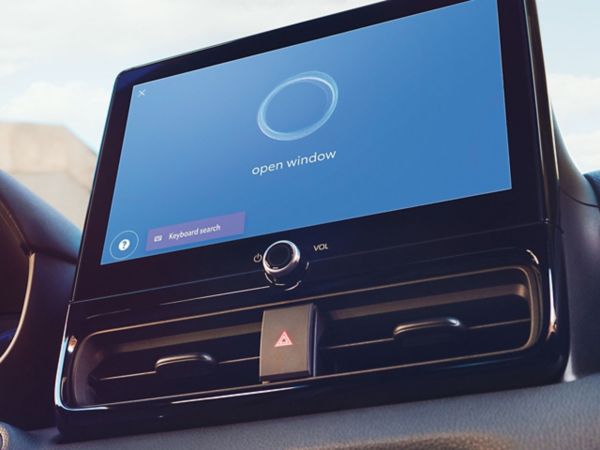 Nahaufnahme eines Multimedia-Displays mit blauem Bildschirm und einem weißen Kreis, darunter der Sprachbefehl "open window".