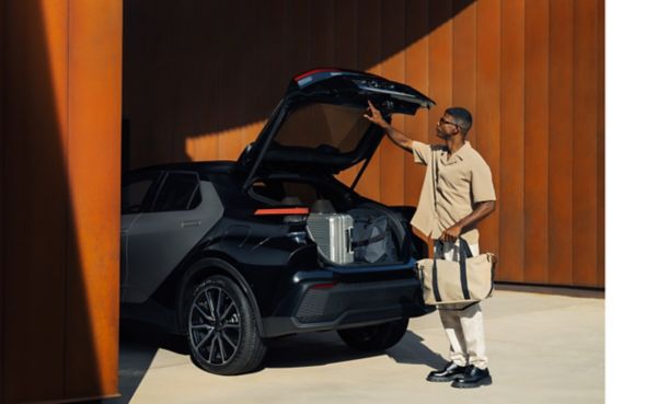 Man taking a bag out of a Toyota CH-R boot and closing the boot