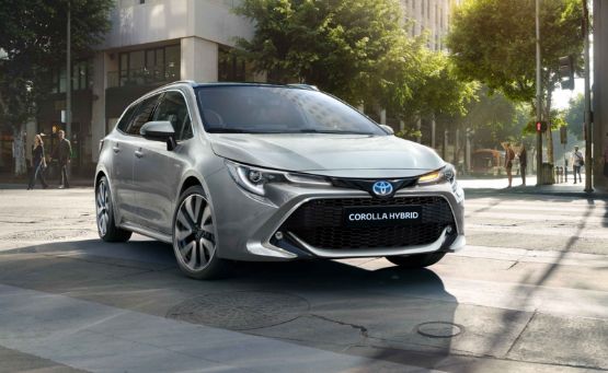 Ezüstszínű Toyota Corolla Hybrid autó egy városi utcán.