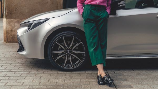 woman leaning on a Corolla