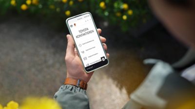 Blick von hinten auf eine Person, die auf ein Smartphone schaut. Hier ist ein Kontaktformular zu sehen.