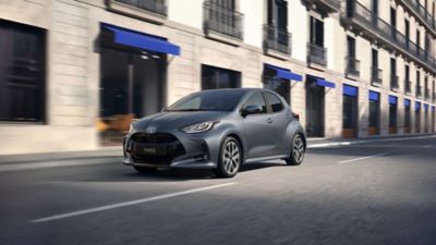 Grauer Toyota Yaris fährt auf einer Straße in einer Innenstadt.
