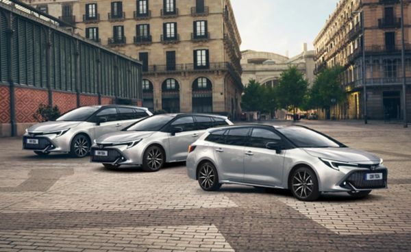 Drei silberne Toyota Corolla Touring Sports stehen auf einem gepflasterten Platz in einer Reihe schräg zu Kamera