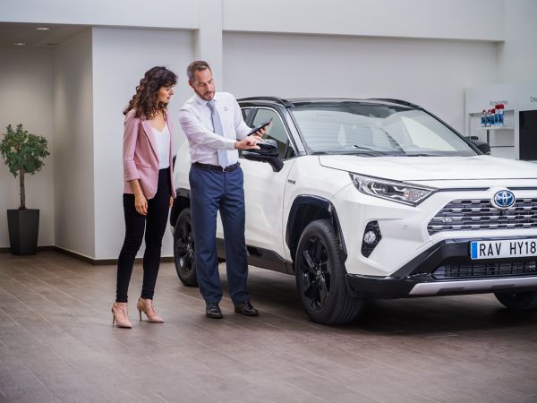 Toyota RAV4 with dealer and customer stood next to it