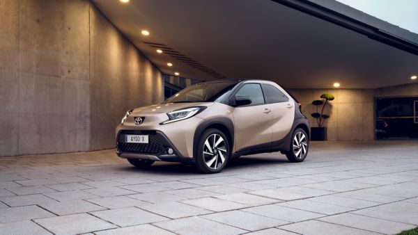 a person leaning on a Toyota car