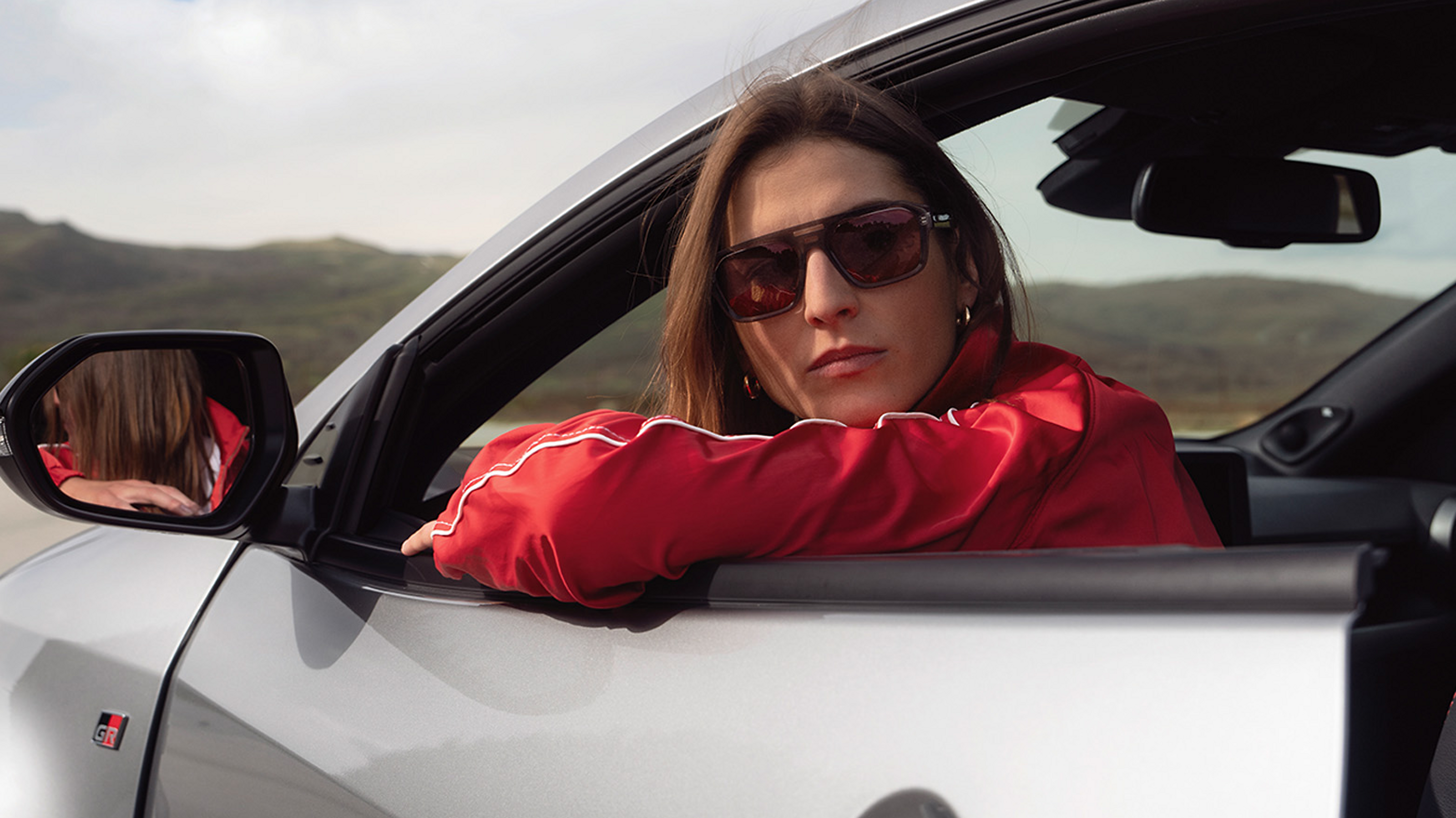 Řidič opírající se o dveře své nové Toyoty GR Yaris