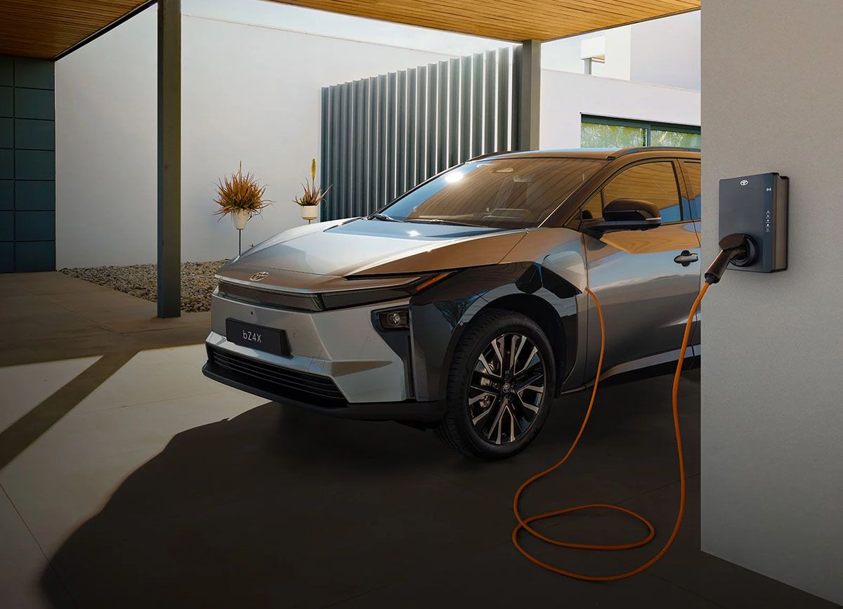 Geparktes E-Auto von Toyota steht unter einem Carport und lädt an einer Wallbox.