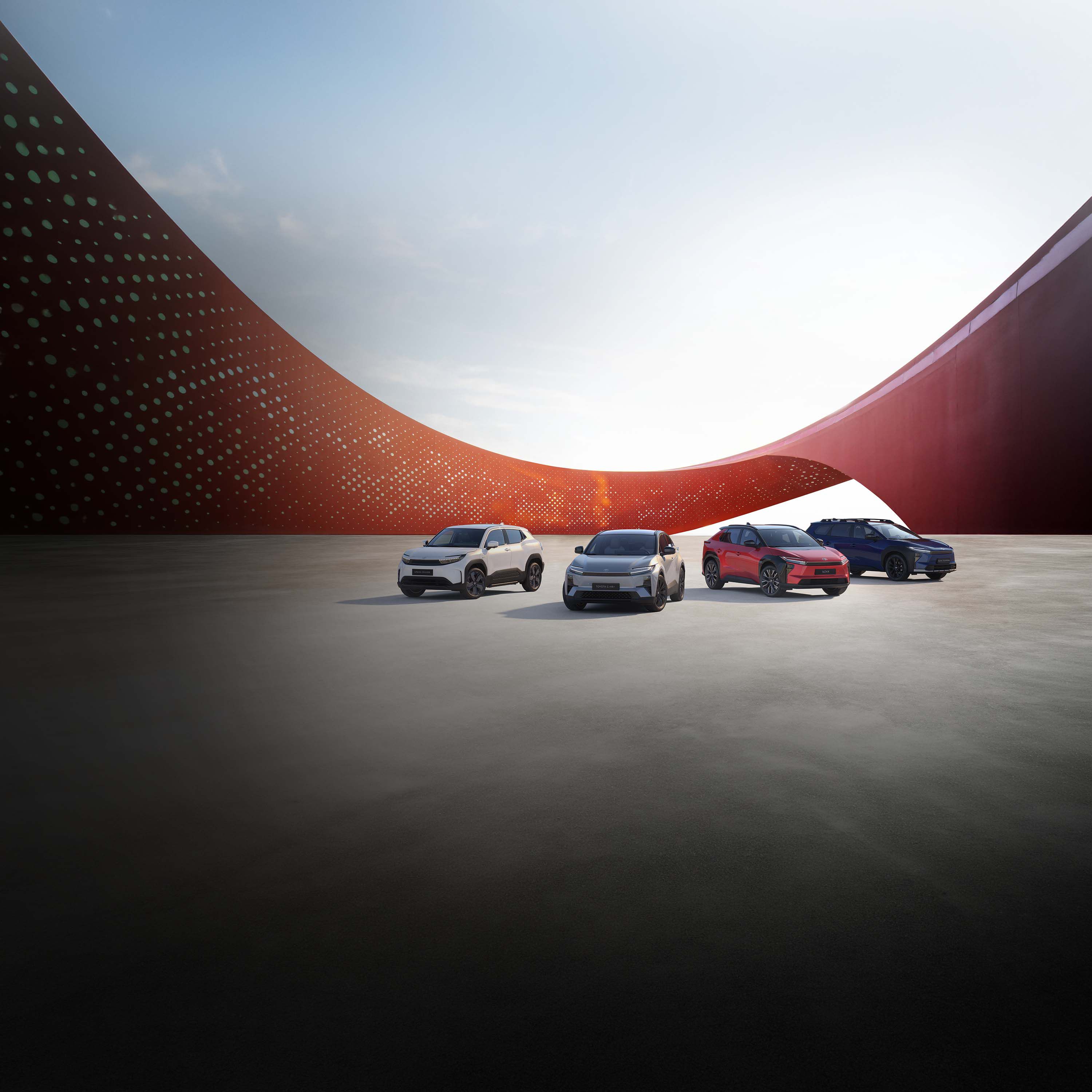 Toyota Urban Cruiser, Toyota C-HR+, Toyota bZ4X und Toyota bZ4X Touring vor modernem Hintergrund.
