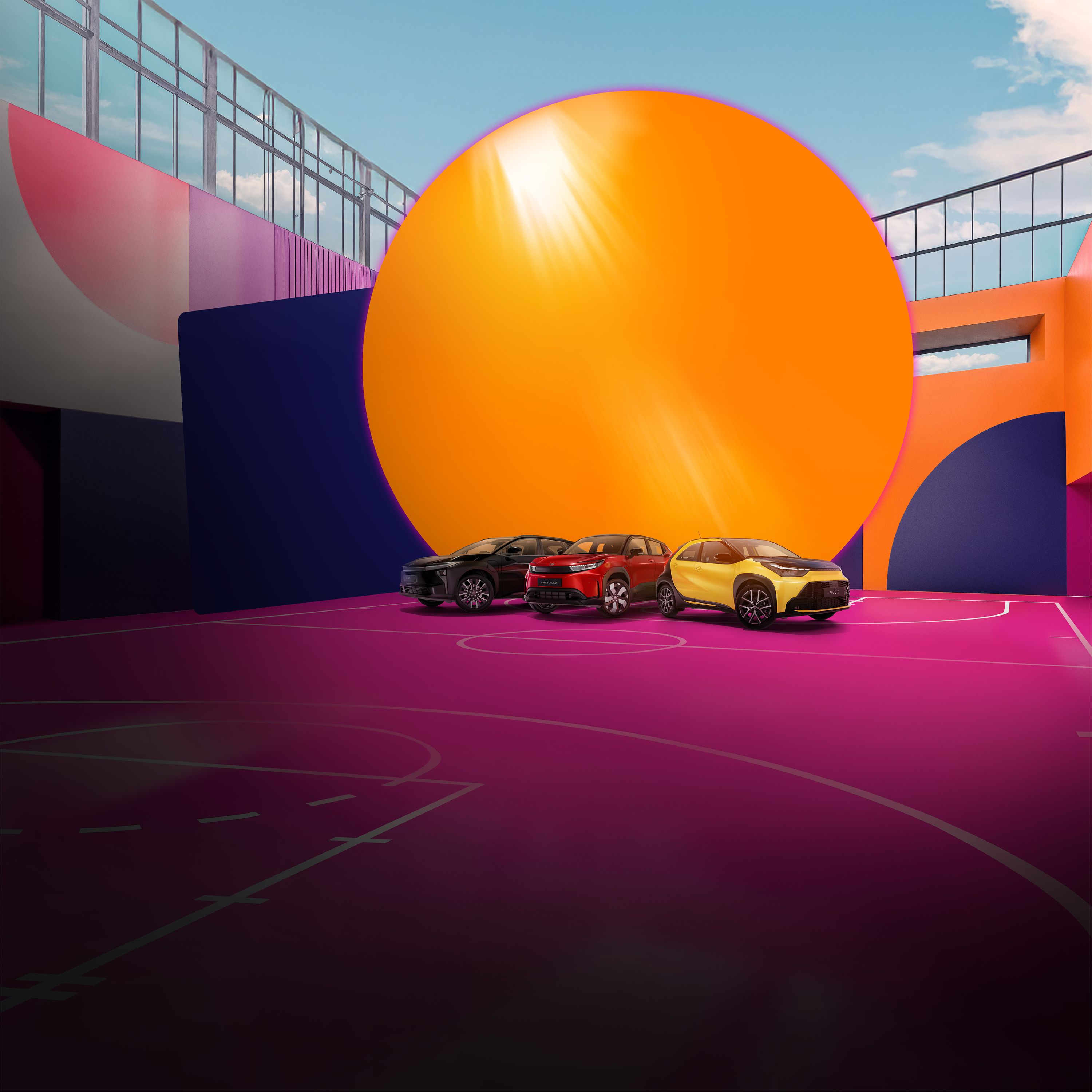 Vier Toyotas stehen auf einem pinken Basketballplatz, der von einer bunt bemalten Wand umgeben ist.