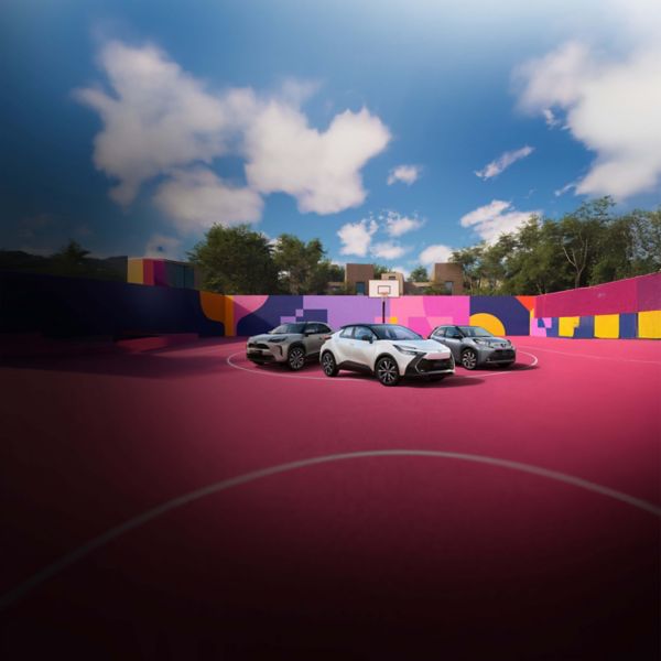 Vier Toyotas stehen auf einem pinken Basketballplatz, der von einer bunt bemalten Wand umgeben ist.
