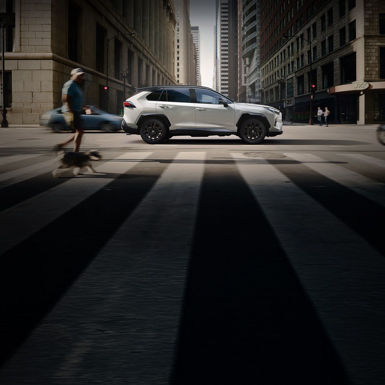 SUV fährt in einer Innenstadt zwischen Häuserschluchten hindurch.