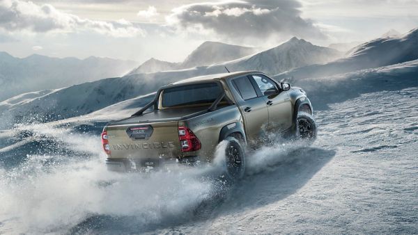 Toyota Hilux driving on the side of a snowy mountain