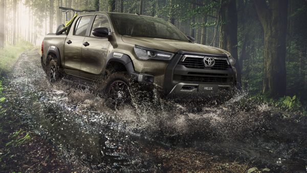 Ormanlık ve sulu bir alandan geçen Toyota Hilux araç