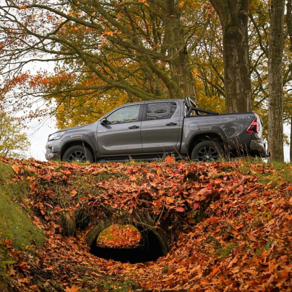 Toyota Hilux 2025 linker zijkant bosrijke omgeving