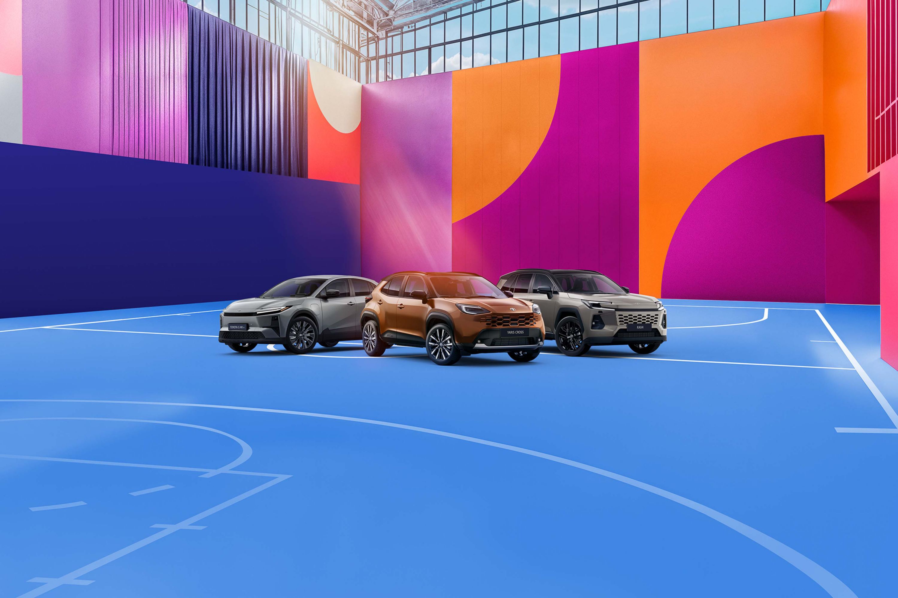 Vier Toyota-Fahrzeuge in Schwarz, Orange und Grau vor einem farbigen, grafischen Hintergrund, nebeneinander auf einer stilisierten Fläche präsentiert.