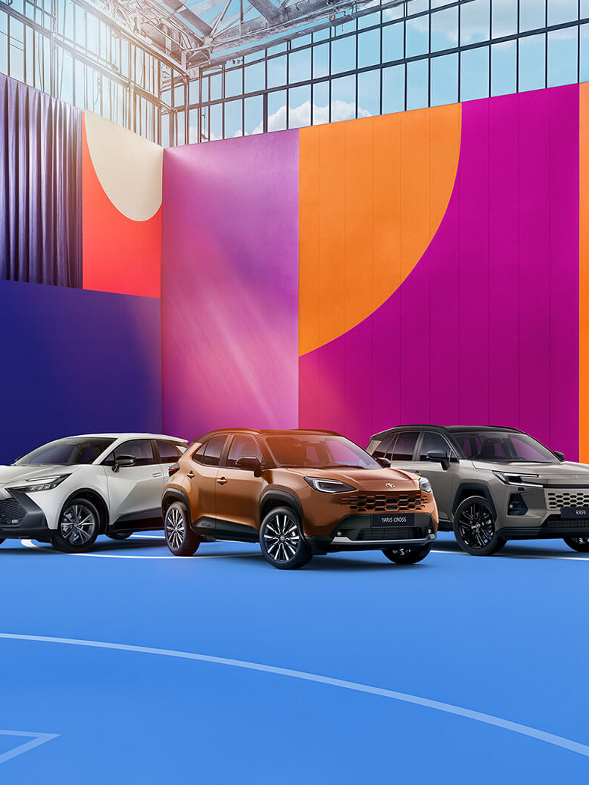 Toyota C-HR, Yaris Cross und RAV4 als SUV-Modelle in einer farbenfrohen Architekturkulisse