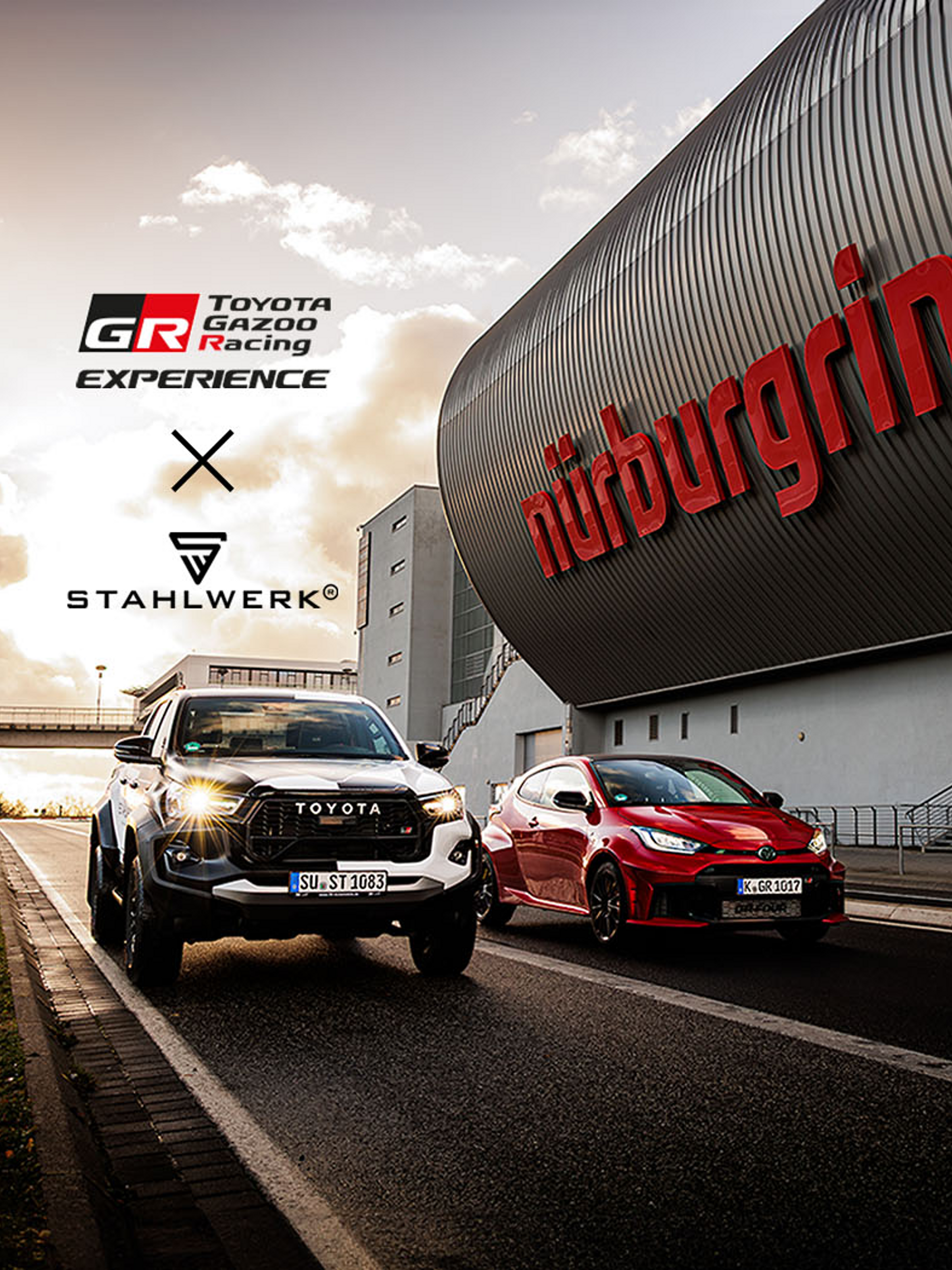 Ein roter GR Yaris und ein silberner, großer SUV von Toyota fahren neben einem Werbebanner mit dem Schriftzug "Nürburgring" über die Rennstrecke, während im Hintergrund das Logo Toyota Gazoo Racing und das Logo von Stahlwerk erscheinen