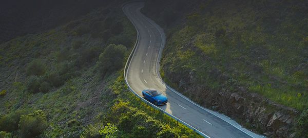 Toyota Mirai jadąca krętą drogą widziana lotu ptaka.