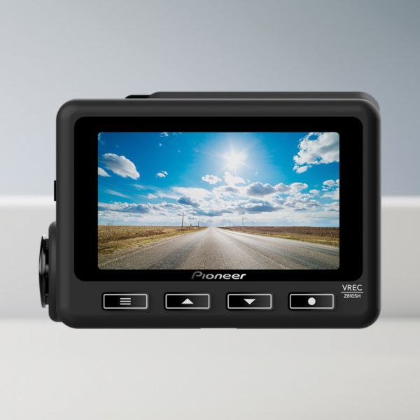 Nahaufnahme einer Pioneer Dashcam mit hellem Bildschirm, auf dem eine leere Landstraße unter blauem Himmel mit Sonnenschein zu sehen ist.