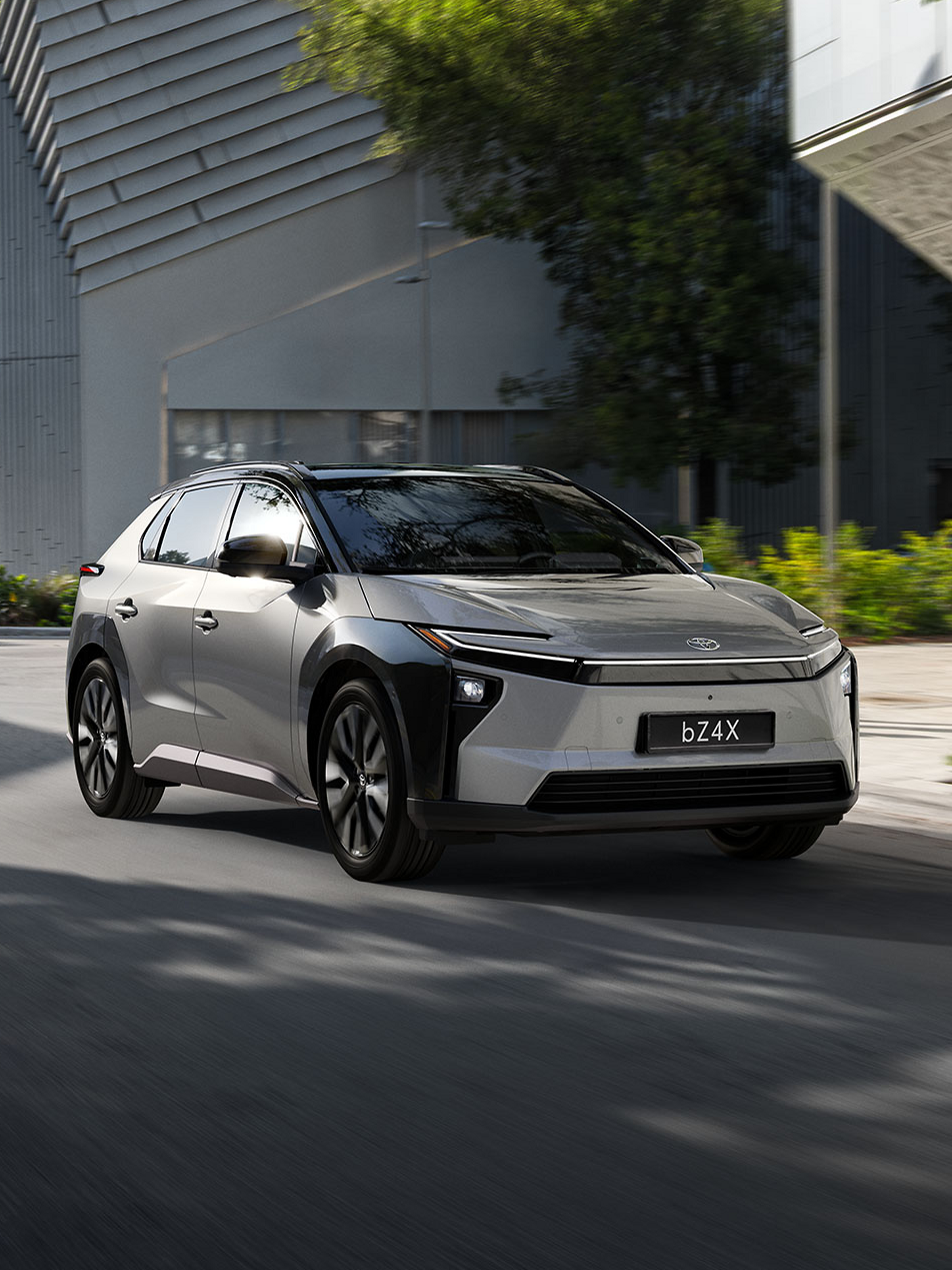 Silberner bZ4X parkt vor einem modernem Haus.