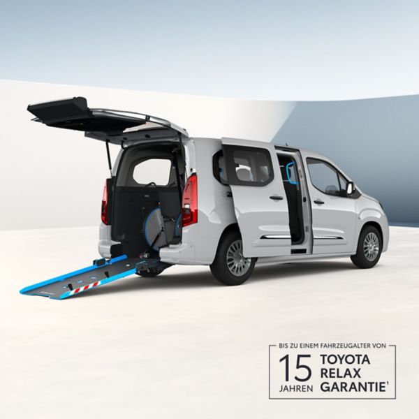 Weißer Toyota Proace City Verso mit geöffneter Heckklappe und ausgefahrener Rollstuhlrampe.