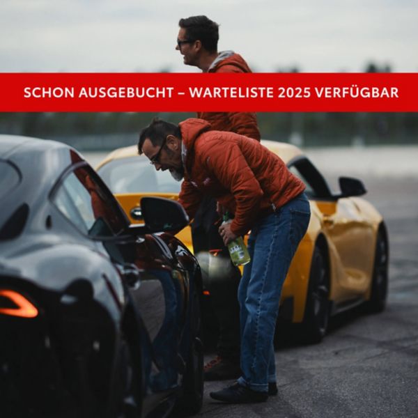 Zwei Rennwagen stehen hintereinander auf einer grauen Straßen, während sich zwei Männer zu einem Autofenster lehnen und mit dem Fahrer sprechen. Aufschrift: Ausgebucht. Warteliste 2025 verfügbar.