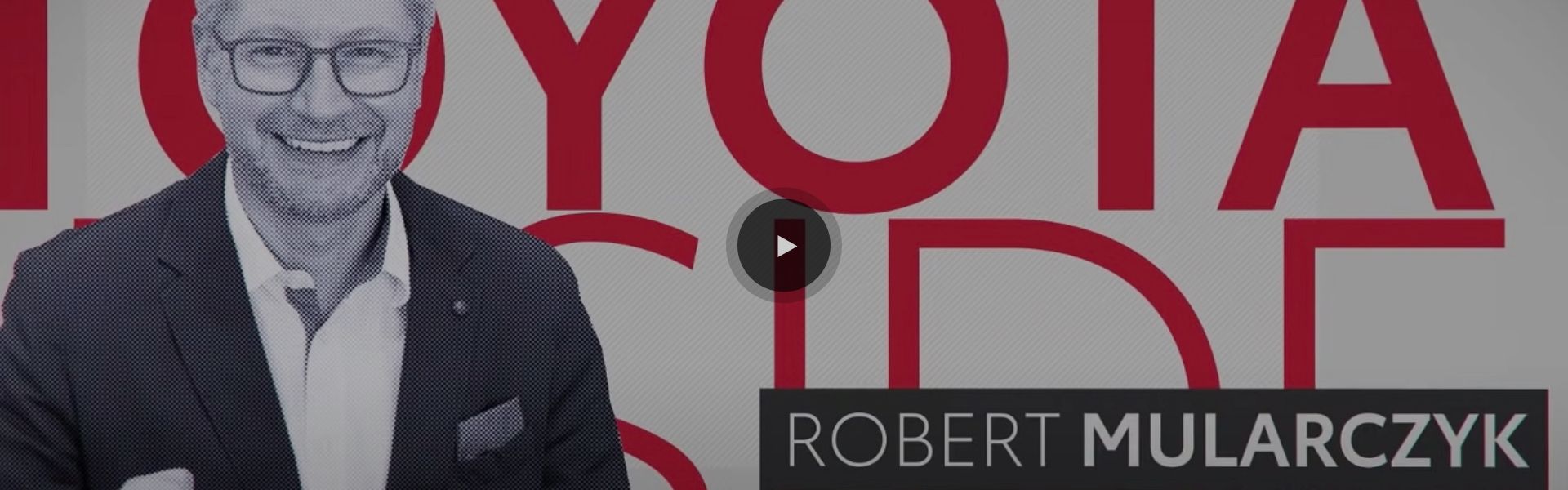 Kadr z filmu: Robert Mularczyk na tle napisu TOYOTA.