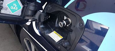 Zbliżenie na otwartą klapkę w nadwoziu w miejscu do tankowania wodoru.