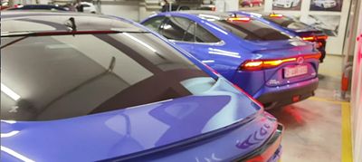 Rząd stojących tyłem modeli Toyoty w salonie.