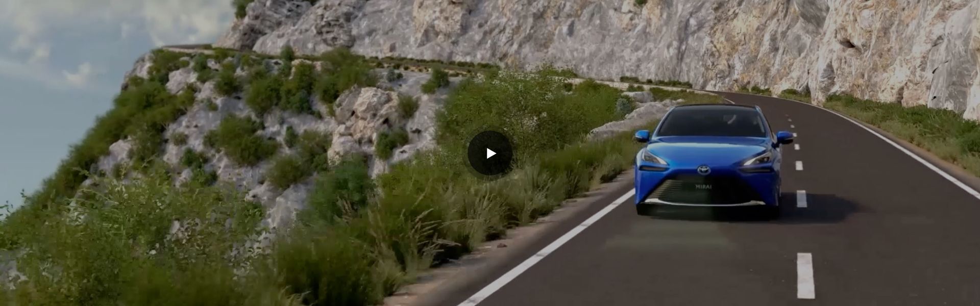 Kadr z filmu: Toyota Mirai jedzie drogą wśród górskiego krajobrazu.