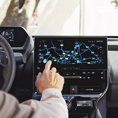 Person tippt auf den Bildschirm eines Multimediabildschirms auf dem eine Karte dargestellt ist