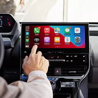 Person tippt auf den Bildschirm eines Multimediabildschirms auf dem mehrere Apps dargestellt sind