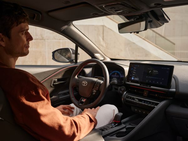 Person sitzt in einem geparkten Toyota und schaut auf das Multimedia-Display in der Mittelkonsole